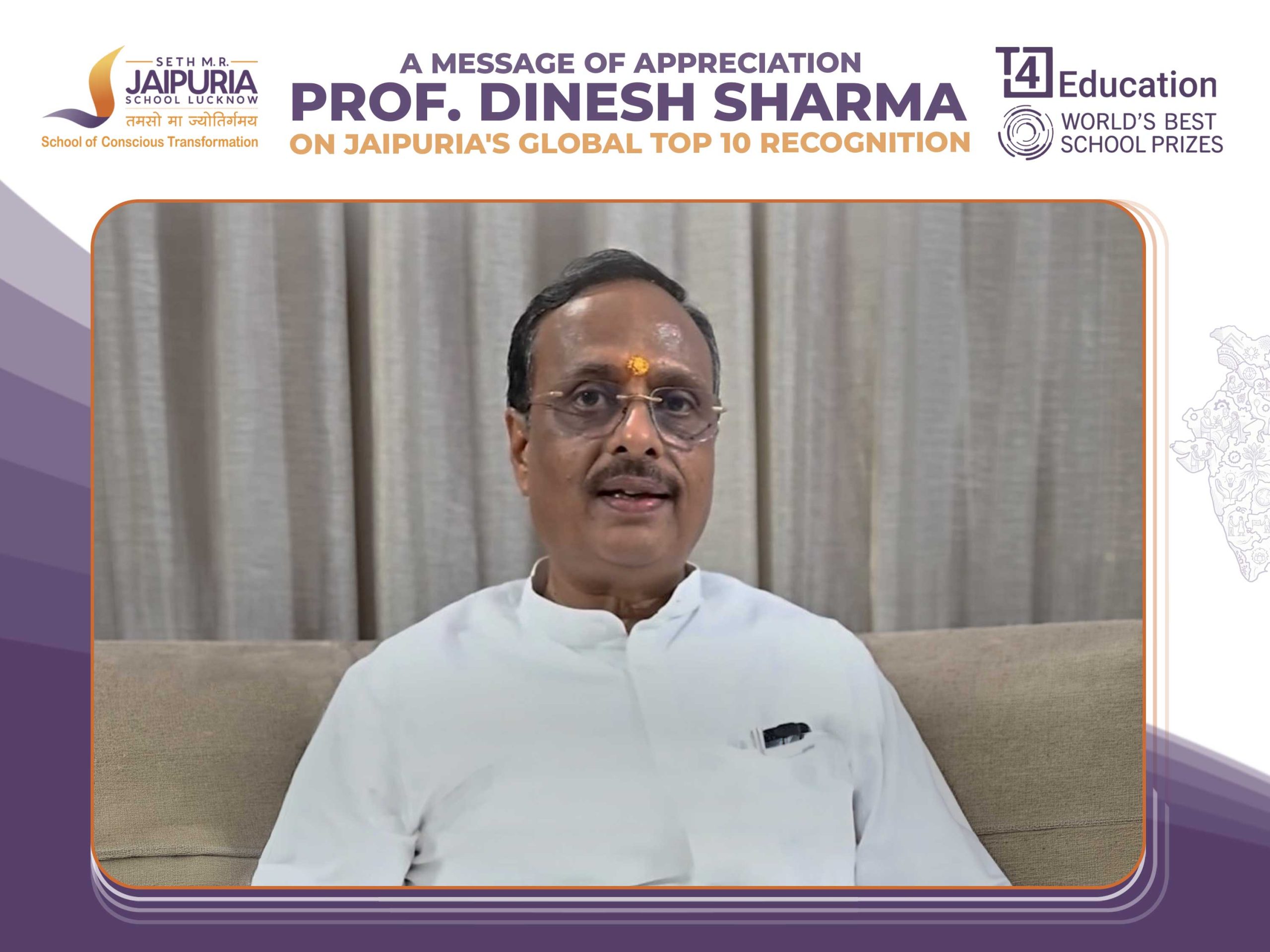 Video frame of a man in a white kurta with tilak, seated on a sofa, speaking, with a congratulatory banner and school logos above.