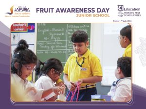 Students in yellow uniforms work together on fruit-themed crafts during Fruit Awareness Day in a classroom setting.