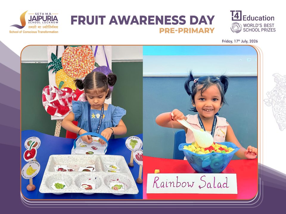 Two young girls participate in a fruit-themed classroom activity with labeled fruit cards at a Rainbow Salad station during Fruit Awareness Day.