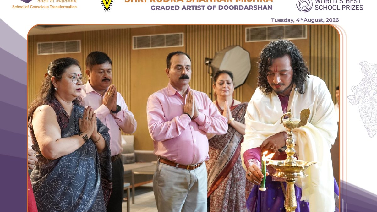 Group of adults praying during a ceremonial lamp-lighting led by a priest holding a lit brass lamp.