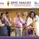 Group of adults praying during a ceremonial lamp-lighting led by a priest holding a lit brass lamp.