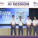 Five students in white shirts stand on stage presenting, with a large 'THANK YOU' screen and a QR code behind them.