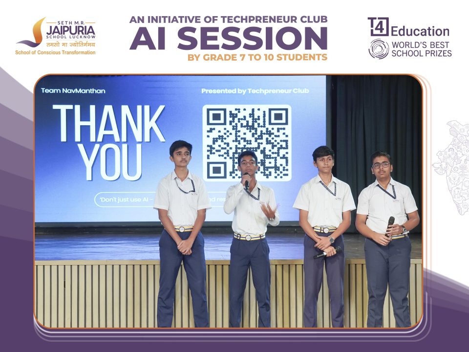 Five students in white shirts stand on stage presenting, with a large 'THANK YOU' screen and a QR code behind them.