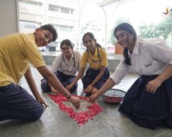 A group of students making a flower rangoli