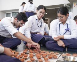 Students filling diyas with oil