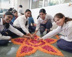 Students crafting a vibrant flower rangoli
