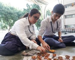 Students filling diyas with ghee